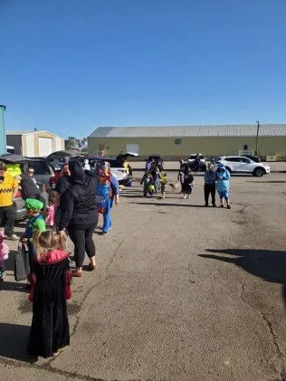 A group of people are standing in a parking lot.